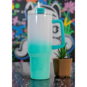 Turquoise gradient shaker bottle with lid and straw, beside a small potted succulent against a colorful chalkboard backdrop.