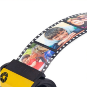 Film strip with multiple photos of smiling children curled along a yellow projector reel edge