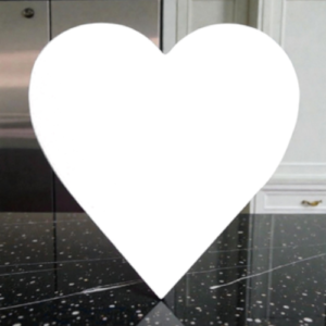 Large white heart silhouette centered on a glossy black speckled kitchen floor.